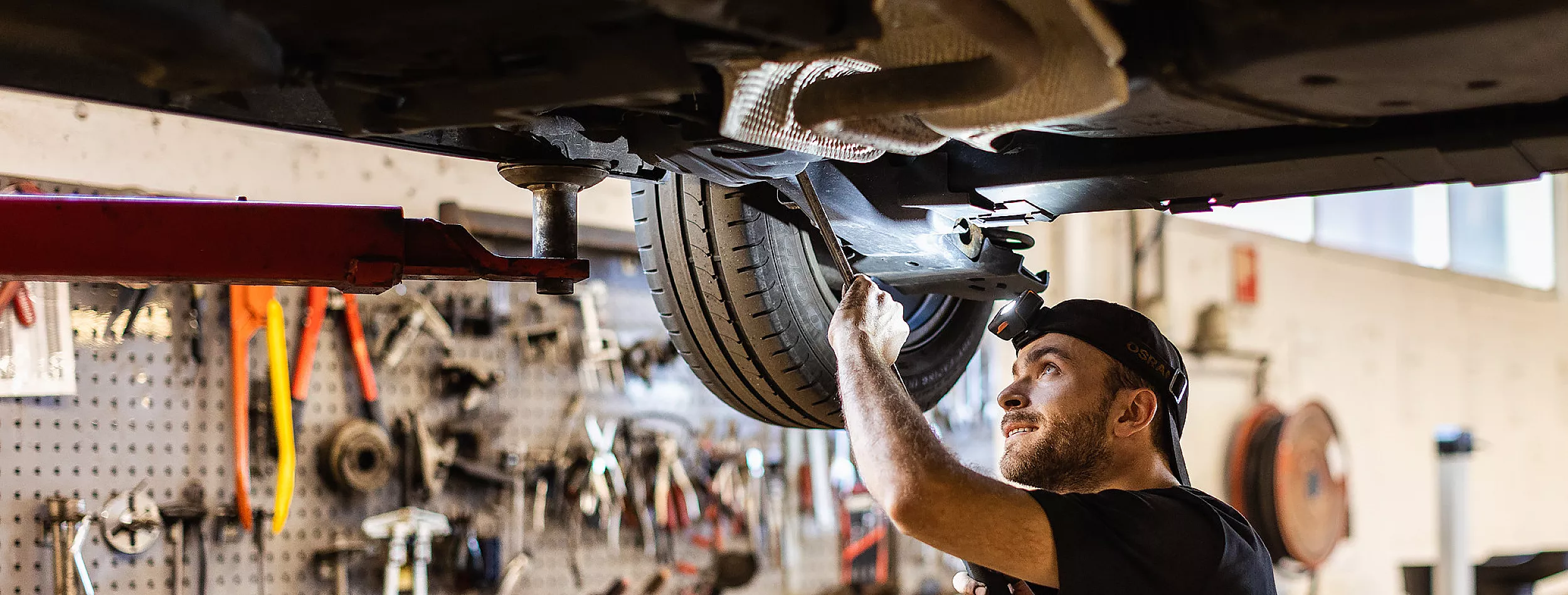 Bilmekaniker godkjent av statens vegvesen utfører EU-kontroll på understellet av bil