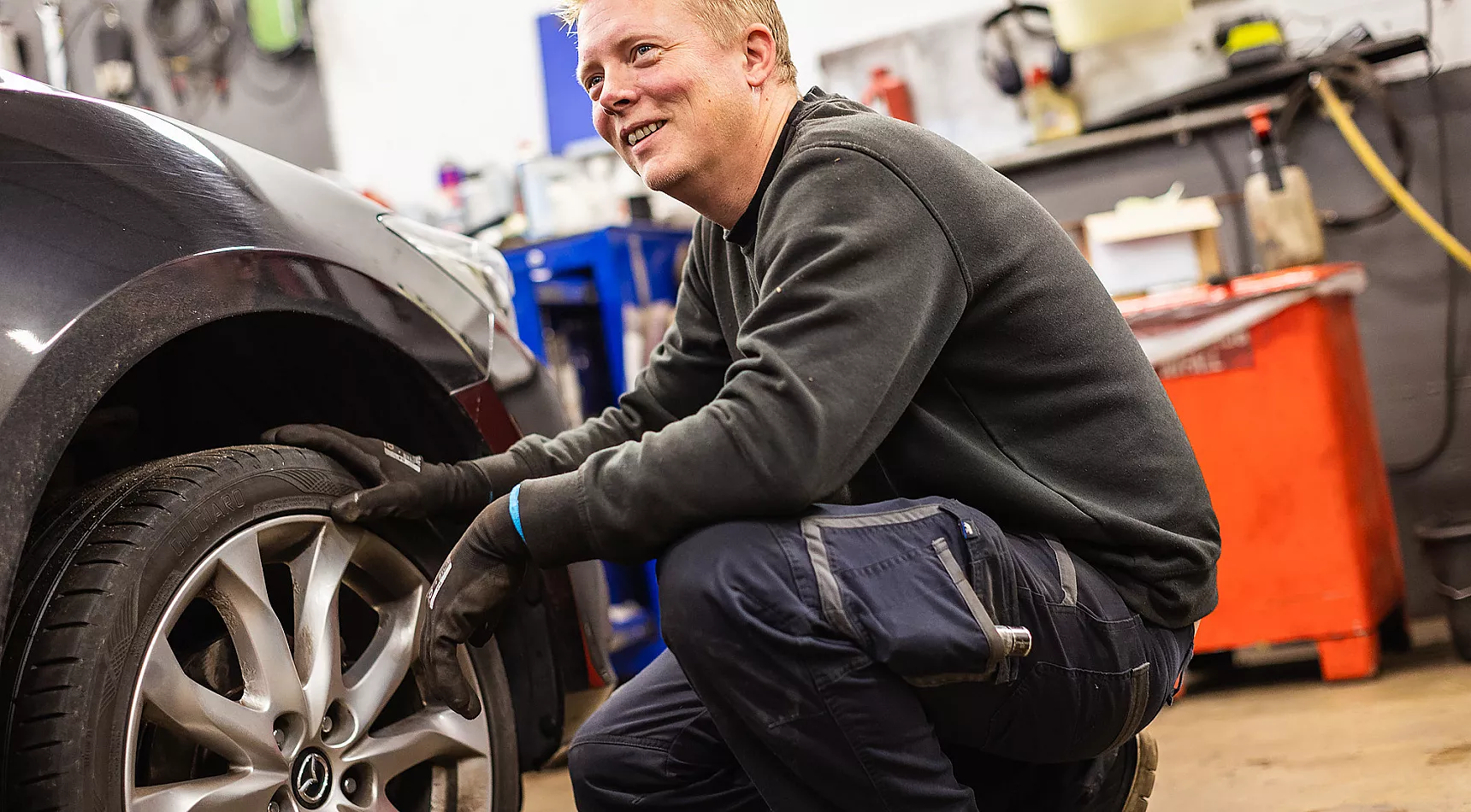 Bilmekaniker i arbeid på en bil hos JP & Thygesen AS